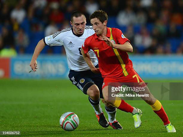 Joe Allen of Wales gets past Scott Brown of Scotland during the FIFA 2014 World Cup Group A Qualifier between Wales and Scotland at City of Cardiff...