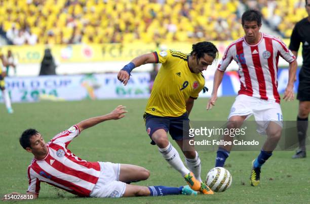Falcao Garcia of Colombia fights for the ball with Ivan Piris and Victor Caceres of Paraguayduring a match between Colombia and Paraguay as part of...