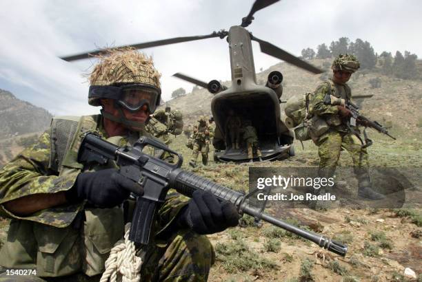 Members of the Princess Patricia's Canadian Light Infantry and U.S. Army personnel arrive by chinook helicopter May 4, 2002 in the Towr Ghar mountain...