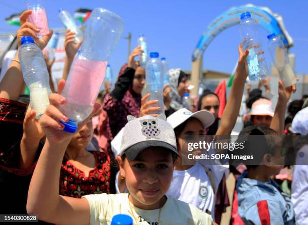 Palestinian children hold plastic bottles with messages in the Mediterranean Sea during a protest against Israel's policies and calling for an end to...