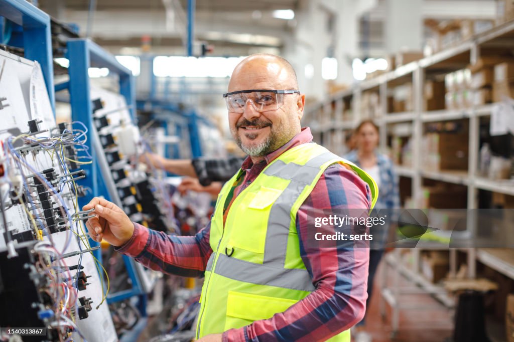 Joyful Work: Smiling Mature Manual Worker Man at Manufacturing Factory