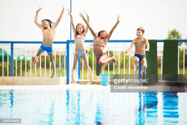 glückliche kinder spielen und spaß zusammen im pool. - boy in swimwear stock-fotos und bilder