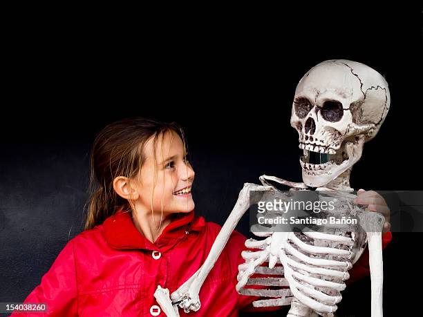 girl smiling at skeleton - funny skeleton stockfoto's en -beelden
