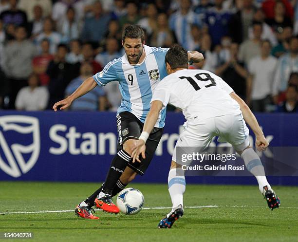 Gonzalo Higuain of Argentina struggles for the ball with Andres Scotti of Uruguay during a match between Argentina and Uruguay as part of the South...