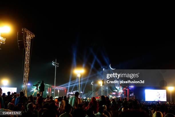 eine gruppe von menschen versammelt sich während der feierlichkeiten zum mahashivratri-fest in der nacht vor der 112 fuß hohen statue des aadiyogi-gottes shiva. - lasershow stock-fotos und bilder