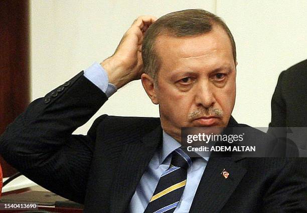 Turkey's Prime Minister Recep Tayyip Erdogan gestures as he listens to Interior Minister Besir Atalay addressing MPs during a debate at the Turkish...