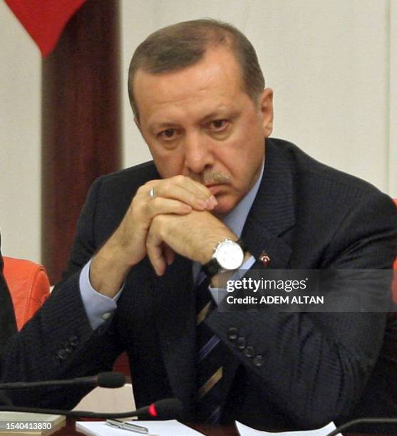 Turkey's Prime Minister Recep Tayyip Erdogan looks on as he listens to Interior Minister Besir Atalay addressing MPs during a debate at the Turkish...