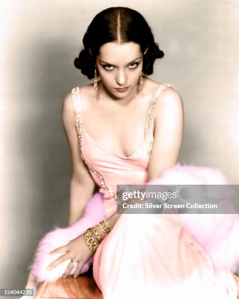 Mexican actress Lupe Velez wearing an evening dress and gold jewellery, circa 1930.