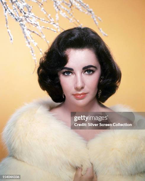 British-born American actress Elizabeth Taylor in a white fur coat, circa 1955.