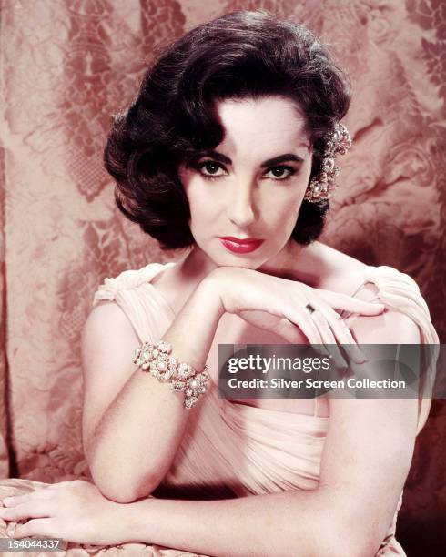 British-born American actress Elizabeth Taylor , wearing an evening gown and a pearl bracelet, circa 1955.