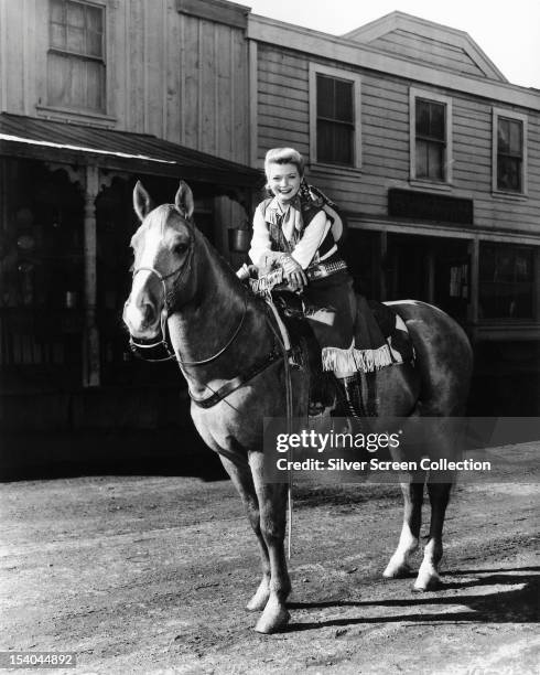 American actress Gail Davis on horseback in the title role of the American TV western series 'Annie Oakley', circa 1955.