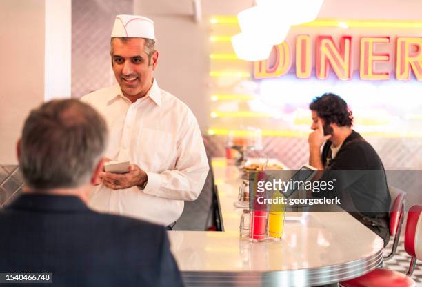 cena tradizionale - man eating at diner counter foto e immagini stock