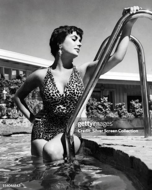 British-born American actress Elizabeth Taylor in a swimming pool, wearing a one-piece, leopard print swimsuit, circa 1955.