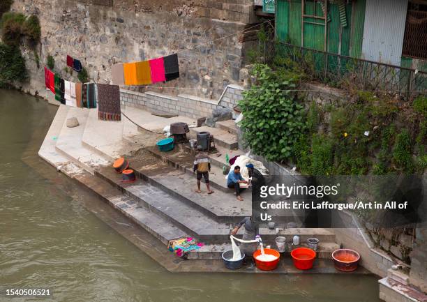 Men washing clothes on the ghat of Jhelum River, Jammu and Kashmir, Srinagar, India on June 12, 2023 in Srinagar, India.