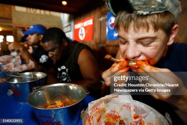 Brandon Hoover , of Humble, chews through a chicken wing as he participates in the Celebrity Wings Eating Competition during the 2007 Harris County...