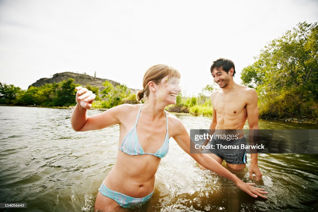 Couple playing in water laughing