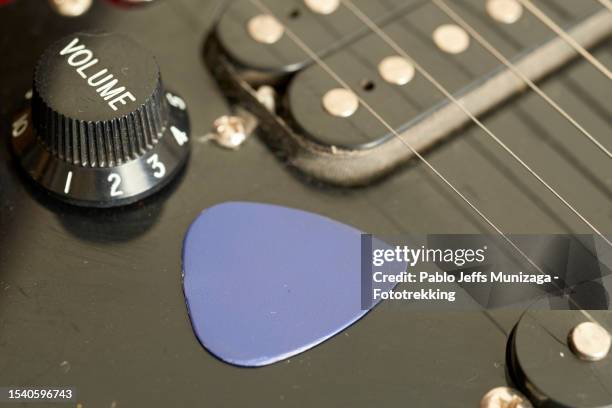 guitar pick near volume knob - gitaarplectrum stockfoto's en -beelden