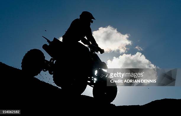 Quad bike rider comes over the crest of a dune during the main quad and sidecar race during the 2012 RHL Weston beach race in Weston-Super-Mare,...
