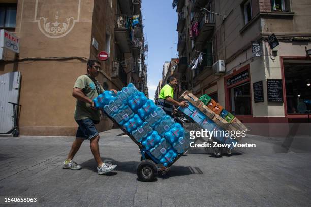 Lider, delivery man for a beverage brand, distributes water for businesses in Barceloneta on July 13, 2023 in Barcelona, Spain. An area of high...