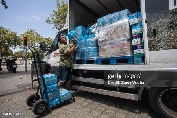 Lider, delivery man for a beverage brand, distributes water for businesses in Barceloneta on July 13, 2023 in Barcelona, Spain. An area of high...