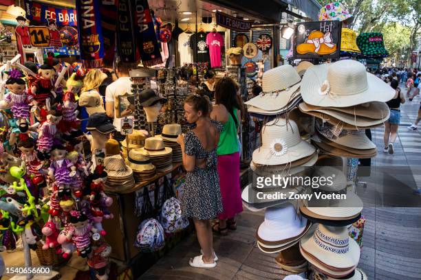 Many souvenir shops sell hats and caps for tourists on the Ramblas on July 13, 2023 in Barcelona, Spain. An area of high pressure, named Cerberus...