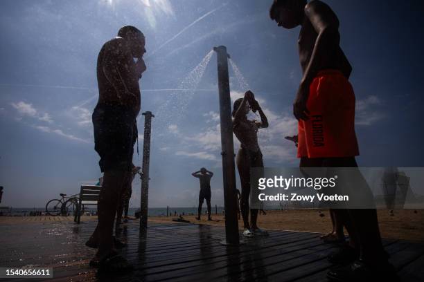 Users of the public showers clean and refresh themselves after leaving the beach. Only one shower on each beach in Barcelona is working this summer,...