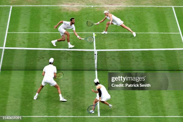 Mate Pavic of Croatia plays a forehand as Lyudmyla Kichenok of Ukraine looks on in the Mixed Doubles Final against Joran Vilegen of Belgium and Yifan...