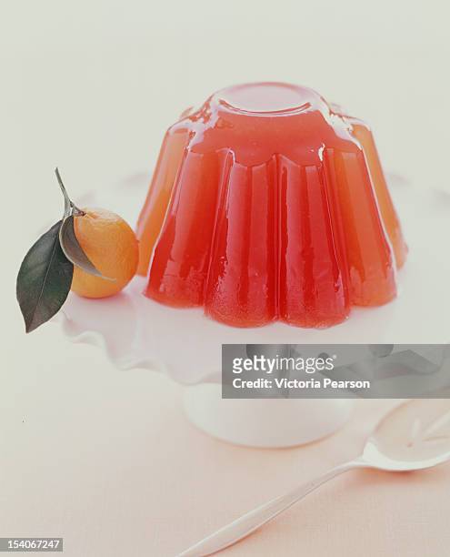gelatin mold on platter with orange. - jello mold stock pictures, royalty-free photos & images