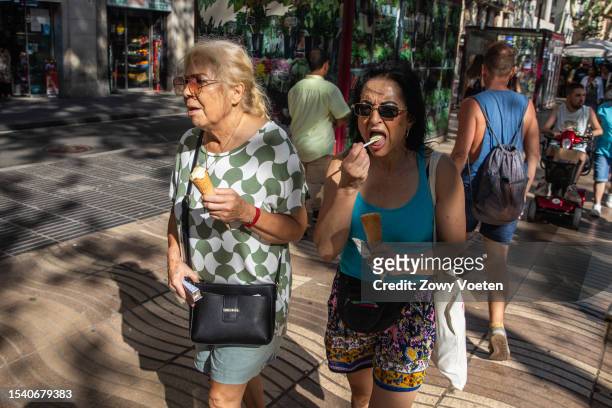 Tourists refreshing themselves with water at the Rambalas trough fountain on July 13, 2023 in Barcelona, Spain. An area of high pressure, named...
