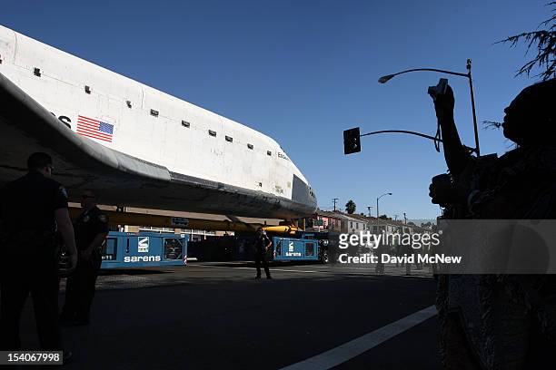 Woman photographs the space shuttle Endeavour as it is transported from Los Angeles International Airport to the California Science Center in...
