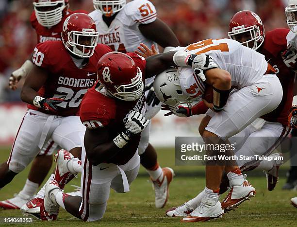 Oklahoma Sooners linebacker Frank Shannon and defensive end David King tries to take down Texas Longhorns quarterback David Ash in the second quarter...