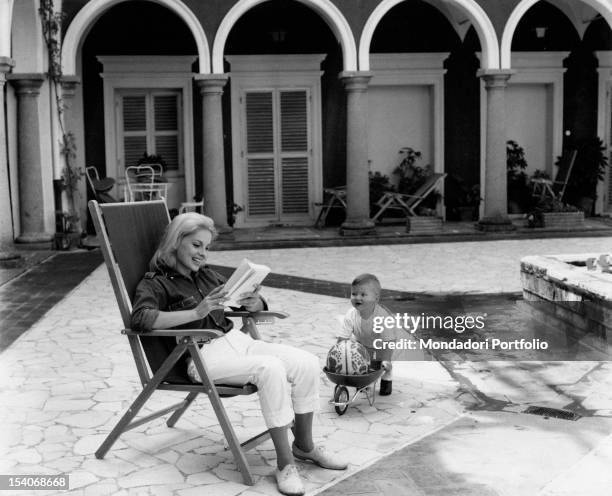 The Italian actress Virna Lisi having fun her son Corrado Pesci in Villa Le Selve courtyard. Marino,1963