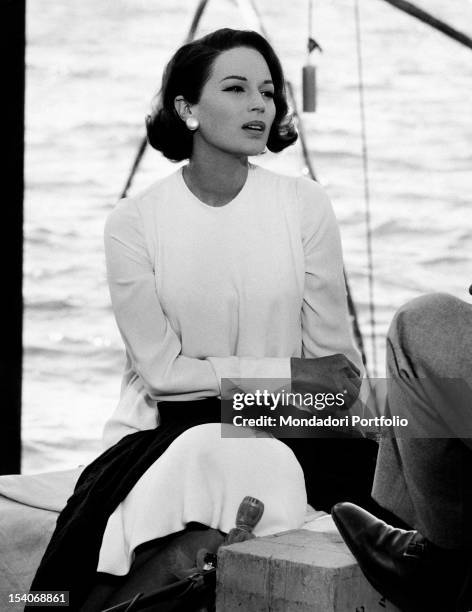 The Italian actress Silvana Mangano sitting by the shore of a basin of water in the film My Wife. 1964