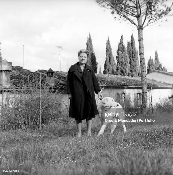 Italian writer and translator Anna Banti photographed in the exterior of her fashionable house in Florence while plays with her dog. Florence , June...