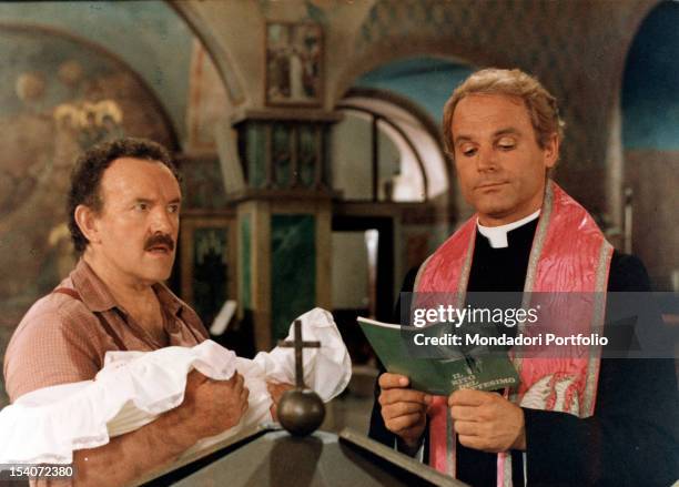 The Italian actor Terence Hill, in the role of Don Camillo, while reading in the church the booklet of the rite of baptism. At his side the British...