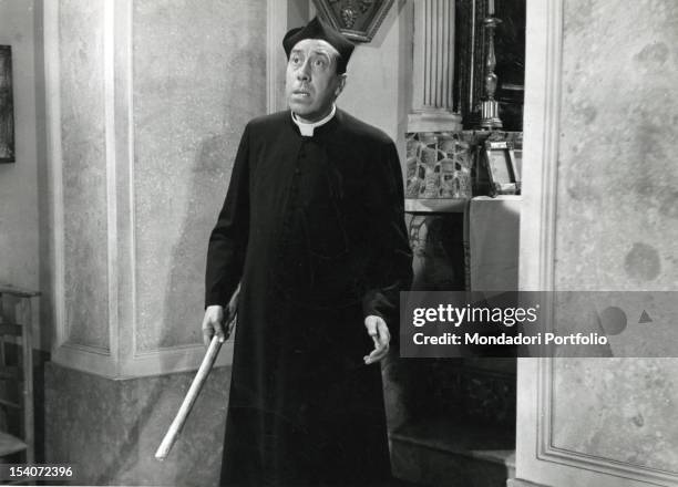 The French actor Fernandel, in cassock with a stick in the hand, playing Don Camillo. Italy, 1952.
