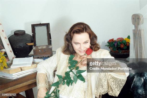 Portrait of Italian actress Laura Antonelli holding a red rose. 1990