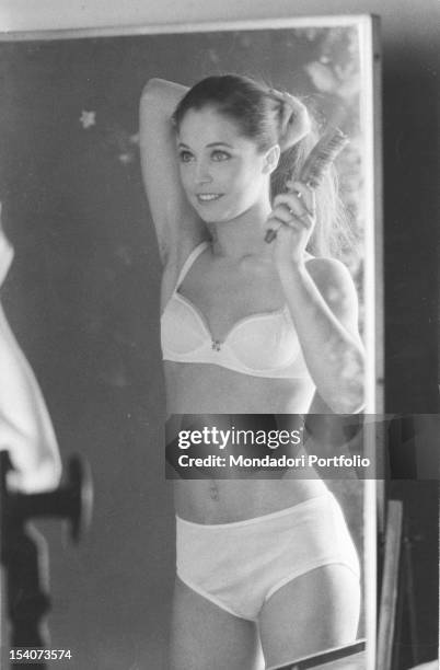 Image reflected by the mirror of the Italian dancer Oriella Dorella, in bra and panties while she is brushing her hair in the dressing room of the...