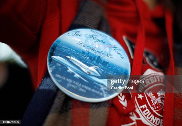 Woman displays a souvenir badge as the Space Shuttle Endeavour is moved to the California Science Center on October 13, 2012 in Inglewood,...