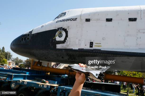 Boy holds a model of the Space Shuttle Endeavour as it is moved to the California Science Center on October 13, 2012 in Inglewood, California. The...