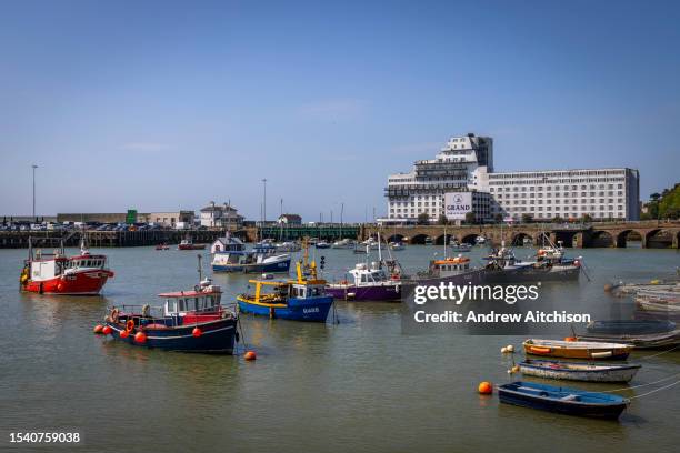 Fishing boats lined up in the other part of Folkestone harbour with the Grand Burstin Hotel in the background on the 20th of May 2023 in Folkestone,...