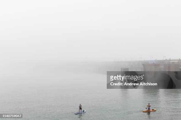 People paddle boarding and kayaking despite a sea mist near Folkestone Harbour Arm on the 12th of June 2023 in Folkestone, Kent, England, United...