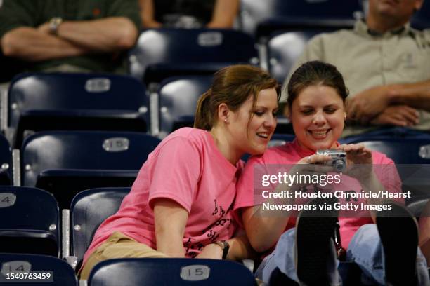 Jayme Widner , left, and her friend Jaime McBride, both of Baytown, enjoy their pictures as they wait for Melissa Etheridge to perform after the 2006...