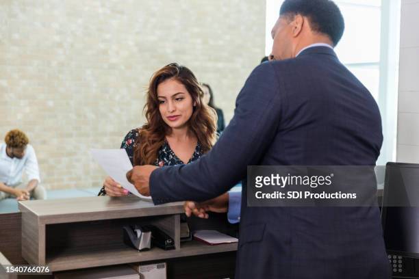 unrecognizable male bank manager explains loan application to woman - credit union stock pictures, royalty-free photos & images