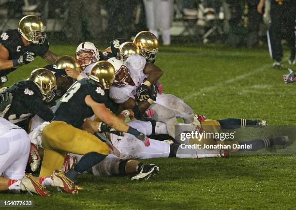 Stepfan Taylor of the Stanford Cardinal is stopped short of the goal by members of the Notre Dame Fighting Irish defense on the last play of the game...