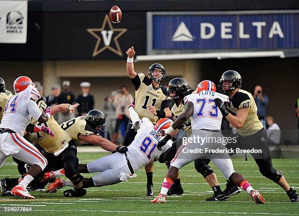 Quarterback Jordan Rodgers of the Vanderbilt Commodores gets hit by Earl Okine of the Florida Gators as he releases a pass at Vanderbilt Stadium on...