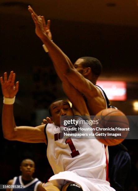 Dion Dowell , left, gets knocked over by Greg Killings of Rice in the second second half of his game at Hofheinz Pavilion on the University of...