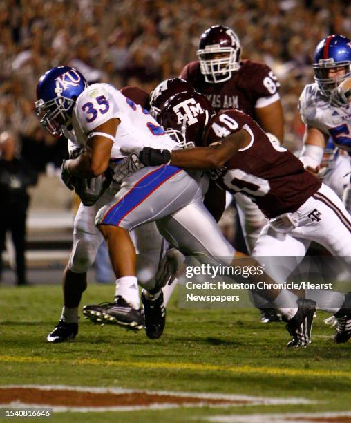 Kansas running back Brandon McAnderson , left, drags Texas A&M's Von Miller for his first touchdown in the third quarter of his game Saturday, Oct....