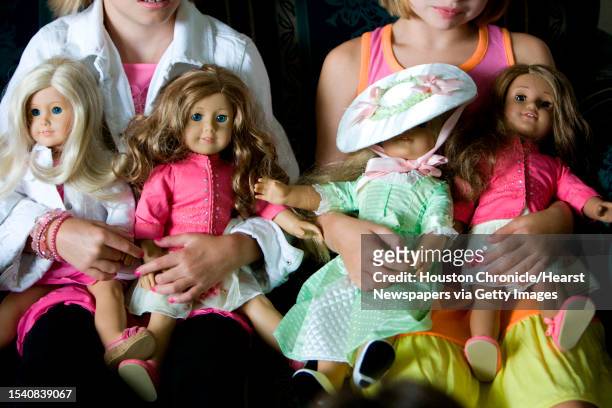 Mary Cate Archinal , left, holds her American Girl dolls as she and Holland Sumrall , both nine and of Houston, show off their dolls a a friends...
