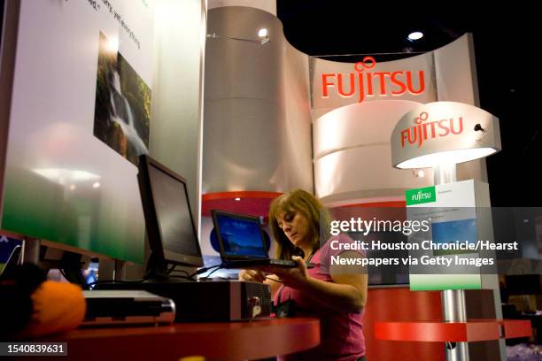 Brigitte Dalton , of Seattle and Fujitsu, prepares her exhibit as exhibitors set up for the Microsoft Worldwide Partner Conference Monday, July 7 in...